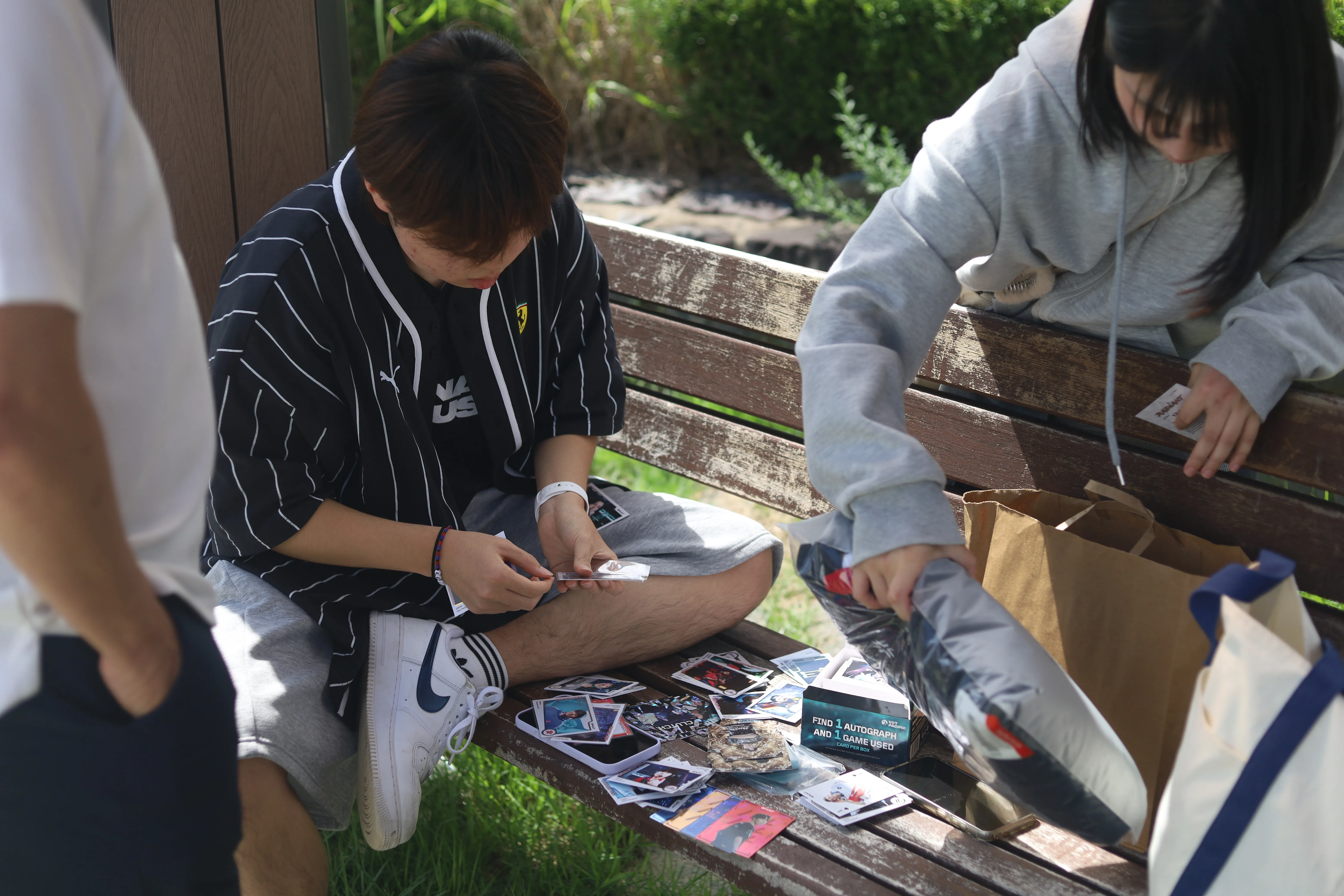 Fans inspect and sort player cards together.